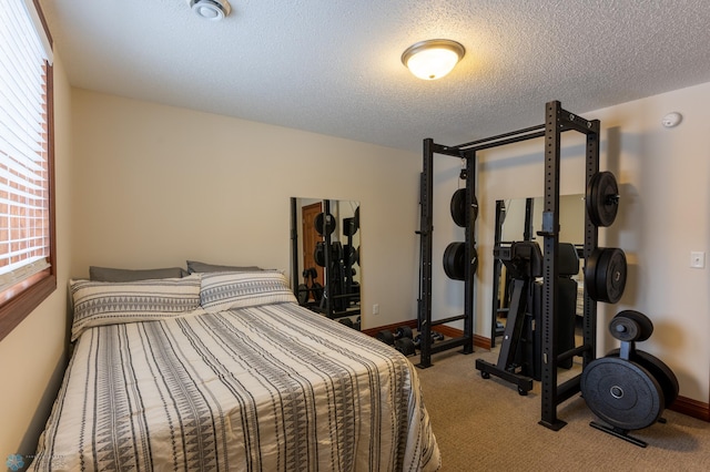 bedroom featuring carpet flooring, multiple windows, baseboards, and a textured ceiling