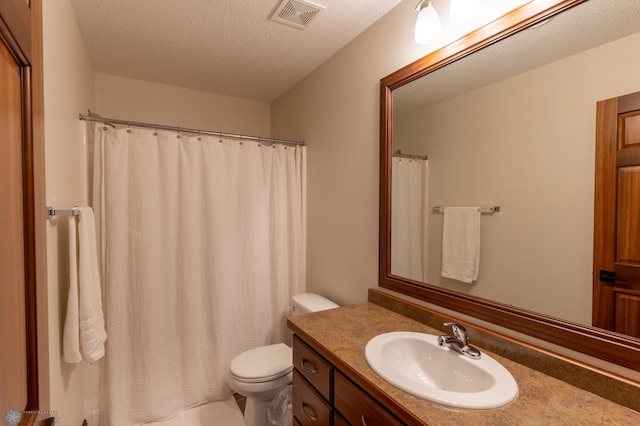 bathroom with visible vents, toilet, vanity, a shower with shower curtain, and a textured ceiling