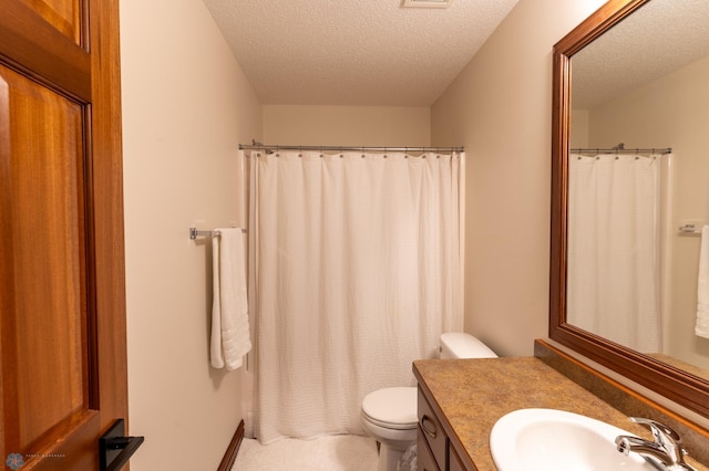 full bathroom with vanity, toilet, and a textured ceiling