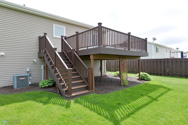 rear view of house with stairs, a yard, central AC unit, and fence