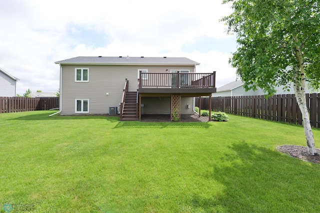 rear view of property with a yard, cooling unit, a fenced backyard, and stairs