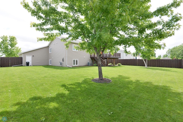 view of yard with a wooden deck and a fenced backyard