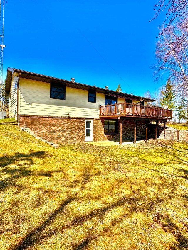 1421 Riverside Dr NW, Baudette, MN 56623 - back of property with a wooden deck, brick siding, and a yard