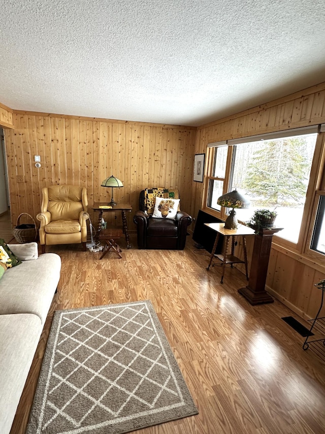 1421 Riverside Dr NW, Baudette, MN 56623 - living room featuring a textured ceiling, wood walls, and wood finished floors