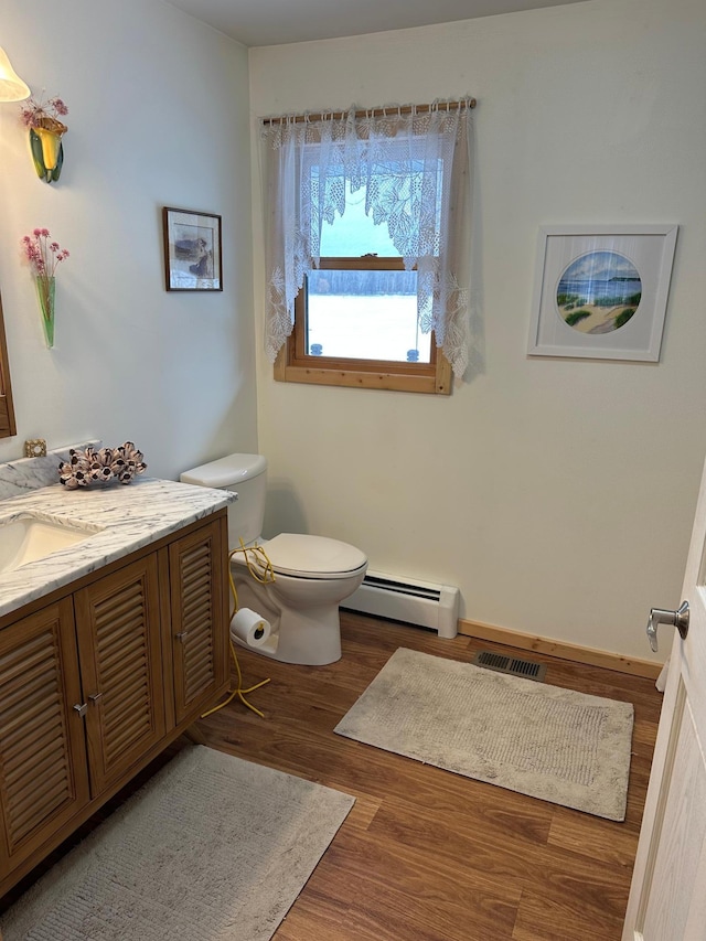 1421 Riverside Dr NW, Baudette, MN 56623 - bathroom with baseboard heating, vanity, and wood finished floors
