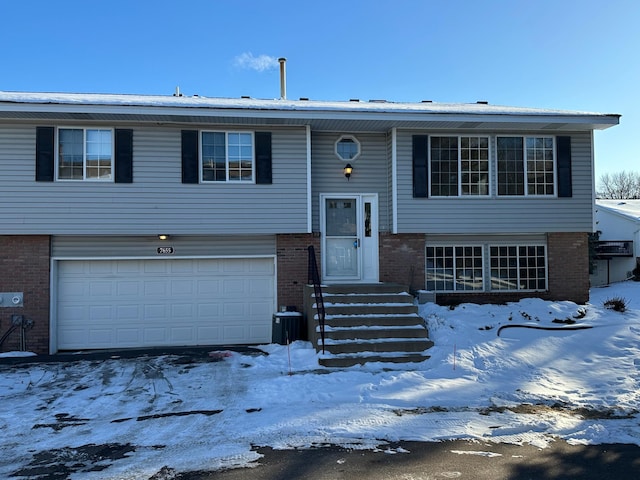 split foyer home featuring a garage and brick siding