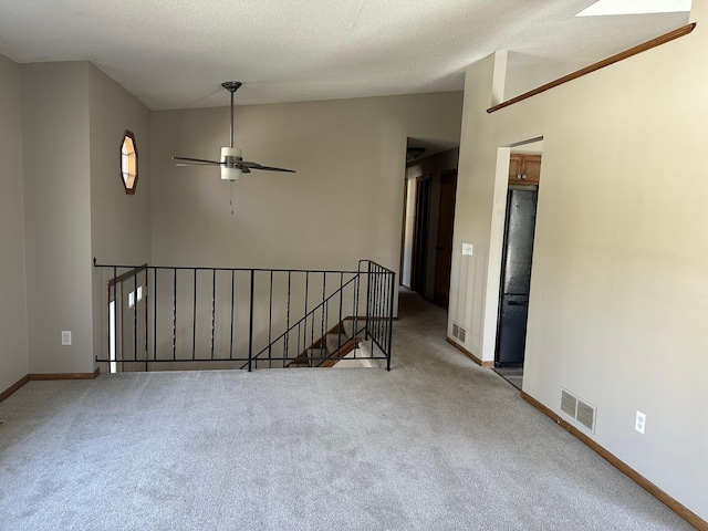 spare room with visible vents, carpet flooring, baseboards, and a ceiling fan