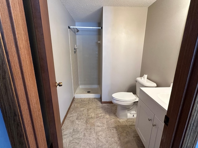 full bathroom with vanity, baseboards, walk in shower, a textured ceiling, and toilet