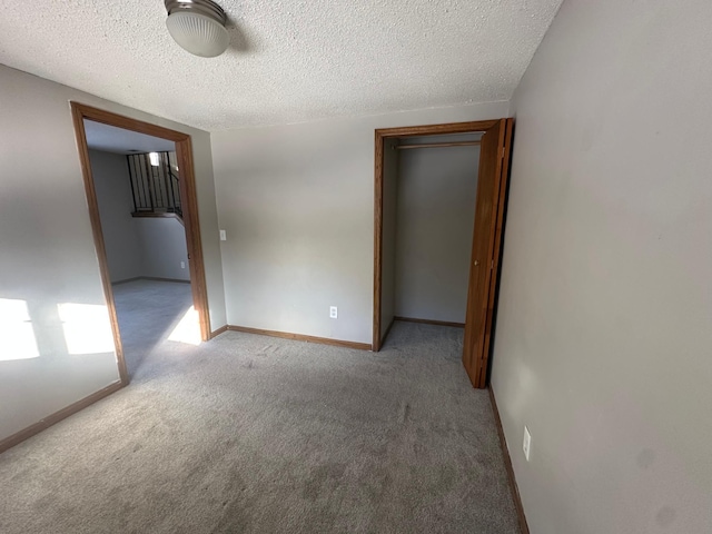 empty room featuring baseboards, carpet floors, and a textured ceiling