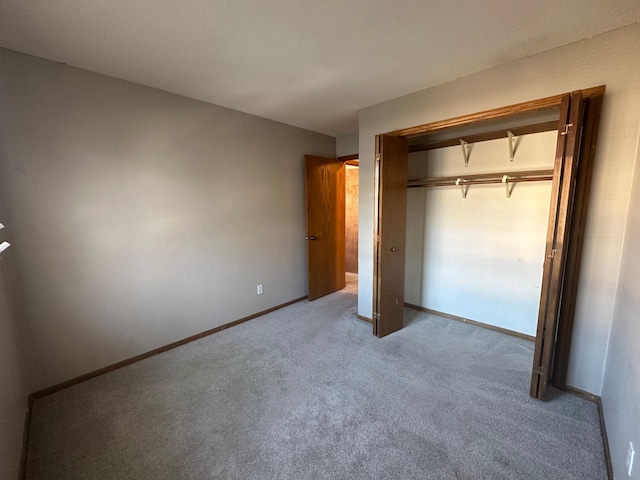 unfurnished bedroom with a closet, baseboards, and carpet floors