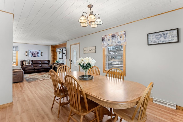 dining area with an inviting chandelier, light wood-style flooring, wood ceiling, and visible vents