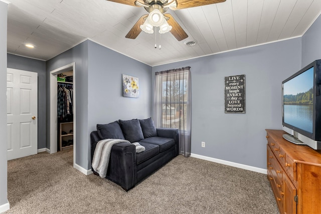 carpeted living area featuring a ceiling fan, baseboards, visible vents, and ornamental molding