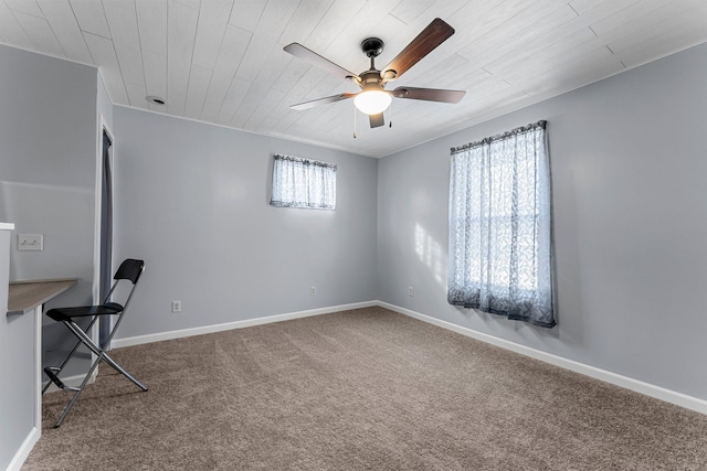 unfurnished office with a ceiling fan, baseboards, and carpet floors