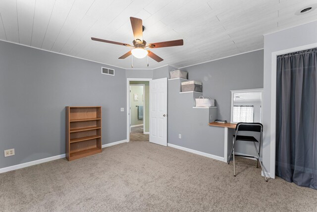 interior space featuring visible vents, carpet, crown molding, baseboards, and ceiling fan