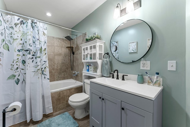 bathroom with toilet, vanity, tiled shower / bath combo, and wood finished floors