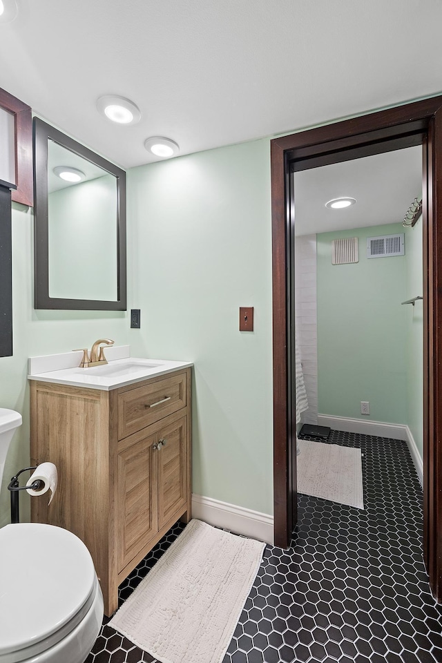 bathroom with vanity, toilet, visible vents, and baseboards