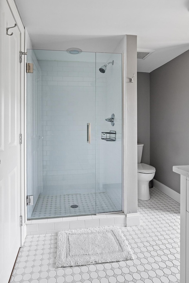 full bathroom featuring baseboards, toilet, and a shower stall