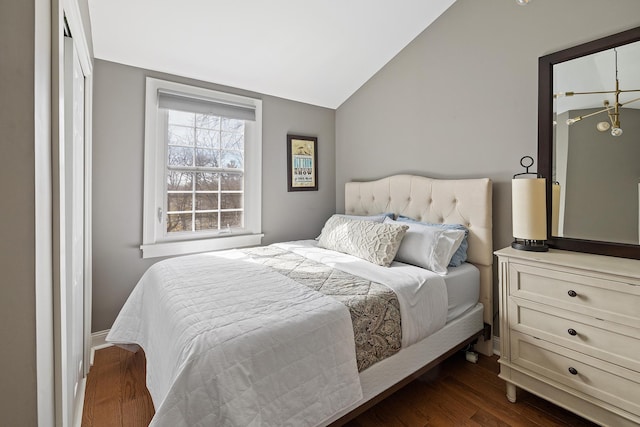 bedroom with dark wood-type flooring and lofted ceiling