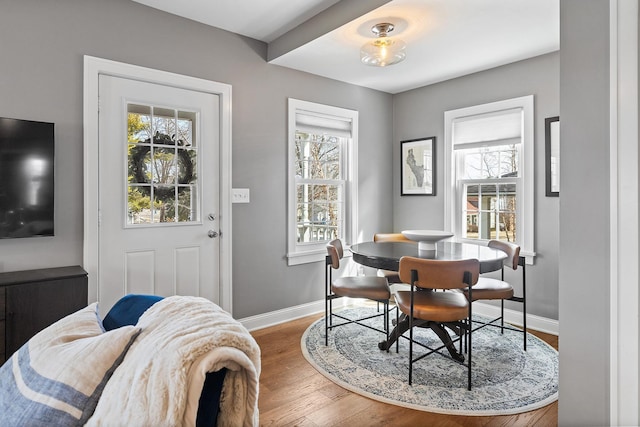 dining area with a wealth of natural light, baseboards, and wood finished floors