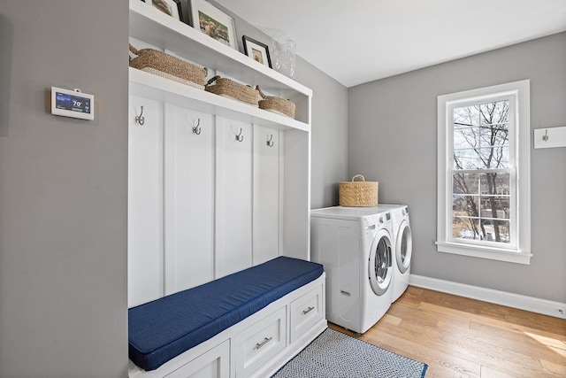 mudroom featuring light wood-style flooring, baseboards, and washer and clothes dryer