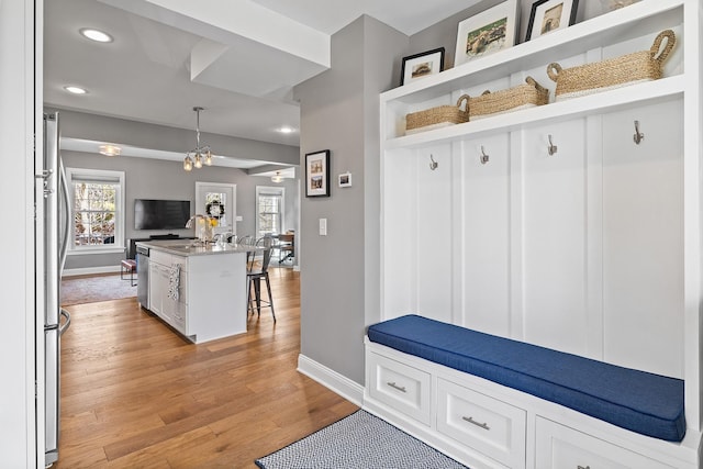 mudroom with recessed lighting, light wood-type flooring, plenty of natural light, and baseboards