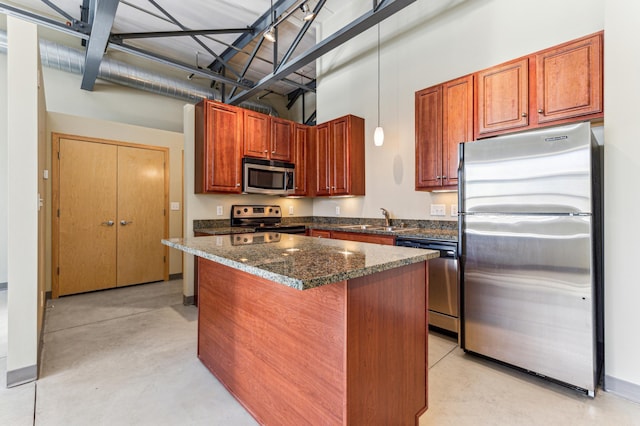 kitchen featuring dark stone countertops, concrete floors, a kitchen island, a sink, and appliances with stainless steel finishes