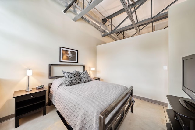 bedroom featuring baseboards and a high ceiling