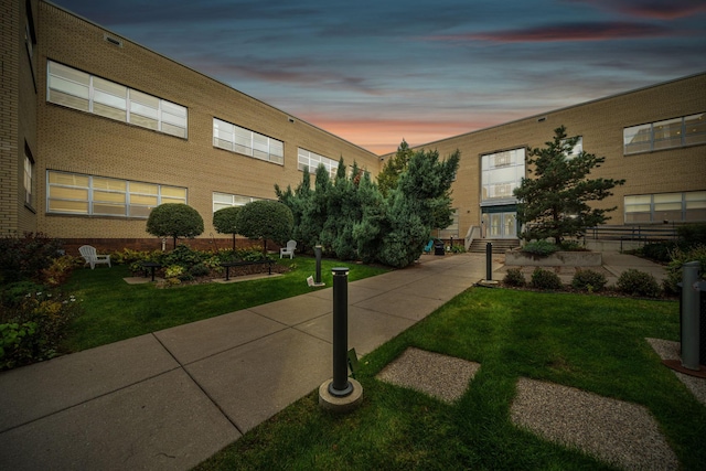 view of property's community with a lawn and entry steps