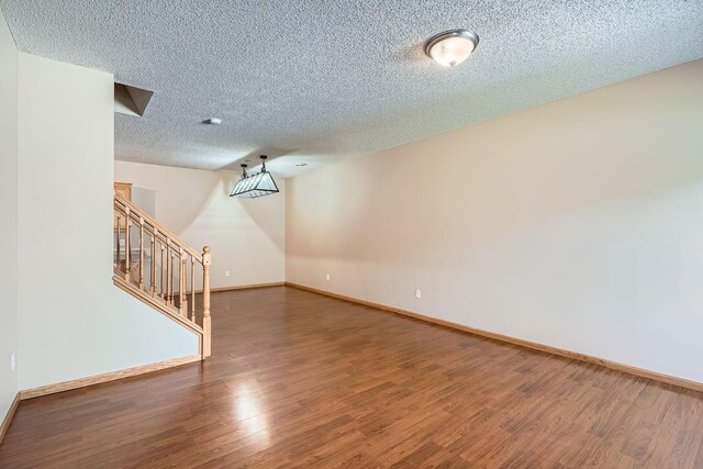 16786 Embers Ave, Lakeville, MN 55024 - empty room with a textured ceiling, wood finished floors, baseboards, and stairway