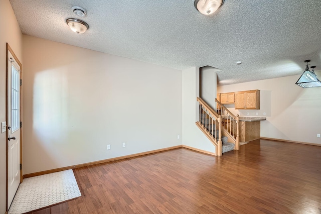 16786 Embers Ave, Lakeville, MN 55024 - unfurnished room with wood finished floors, stairs, baseboards, and a textured ceiling