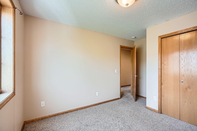16786 Embers Ave, Lakeville, MN 55024 - unfurnished bedroom featuring light colored carpet, a textured ceiling, a closet, and baseboards