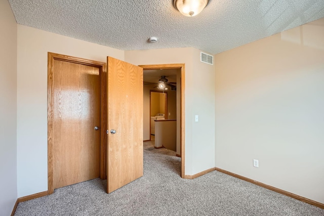 16786 Embers Ave, Lakeville, MN 55024 - unfurnished bedroom with carpet flooring, a closet, baseboards, and a textured ceiling