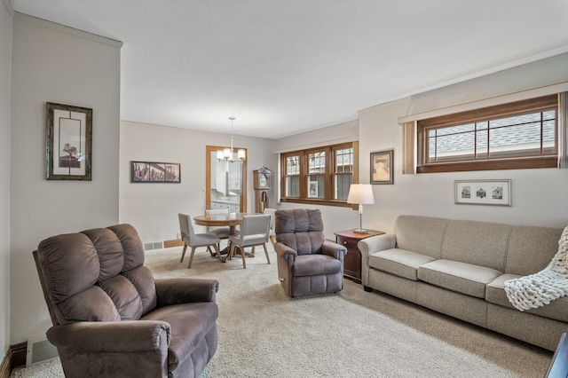 living room featuring an inviting chandelier, carpet flooring, baseboards, and visible vents