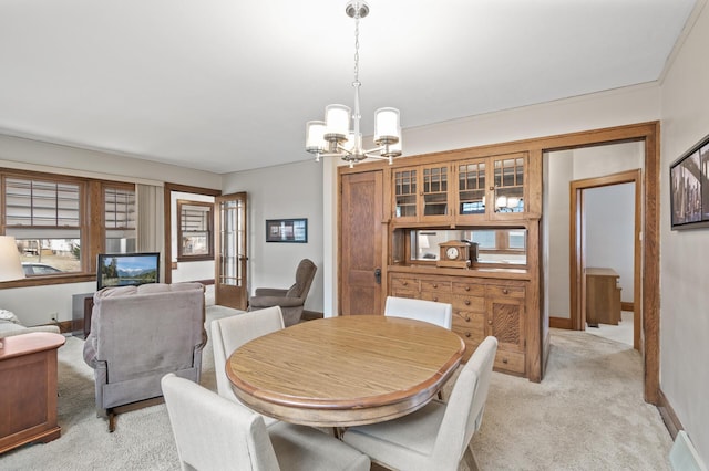 dining room featuring light colored carpet, baseboards, and an inviting chandelier