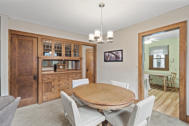 dining room with light carpet and an inviting chandelier