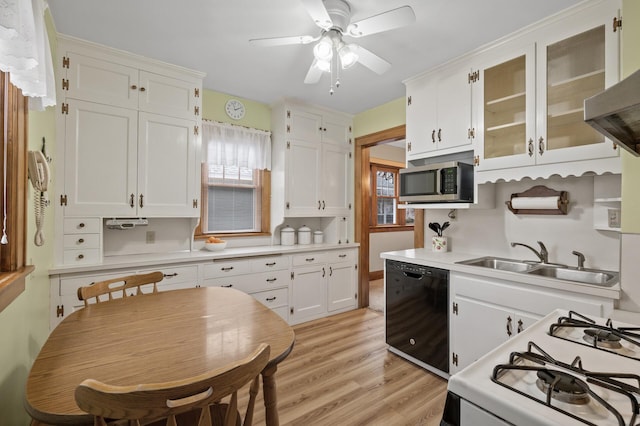 kitchen with stainless steel microwave, gas range gas stove, black dishwasher, white cabinets, and light countertops