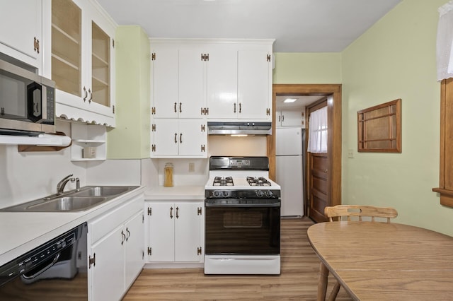 kitchen with light wood-style flooring, under cabinet range hood, a sink, white cabinetry, and white appliances