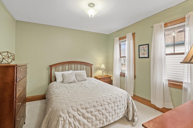 bedroom with baseboards and light colored carpet