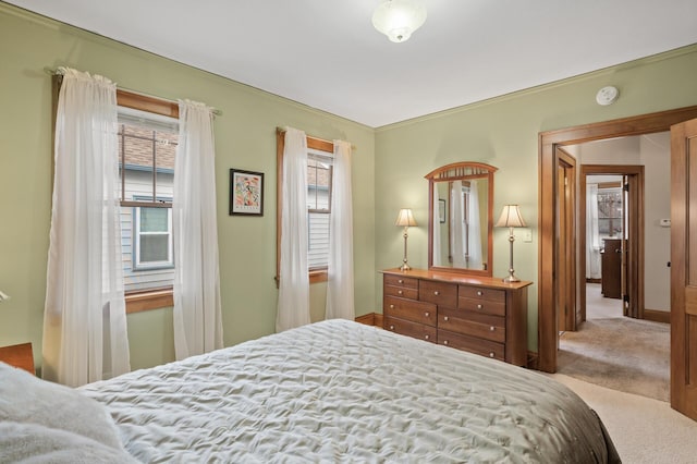 carpeted bedroom featuring multiple windows and baseboards