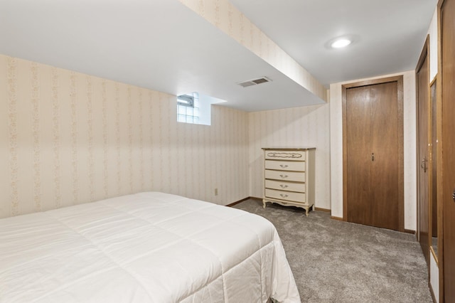 carpeted bedroom with wallpapered walls, baseboards, and visible vents