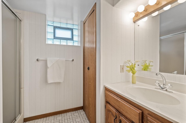 full bathroom featuring an enclosed shower, baseboards, and vanity