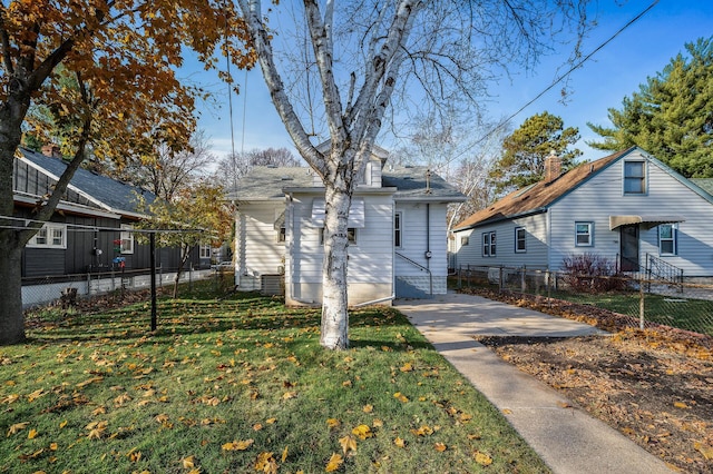 view of side of property with a lawn and fence