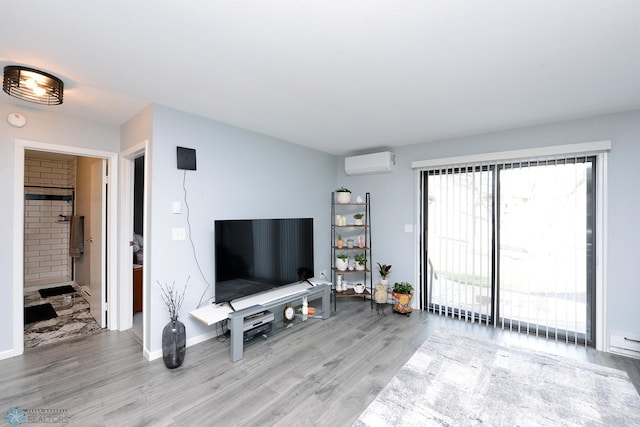 unfurnished living room with a wall unit AC, light wood-style floors, and baseboards