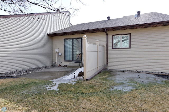 exterior space featuring a yard, a patio, and roof with shingles