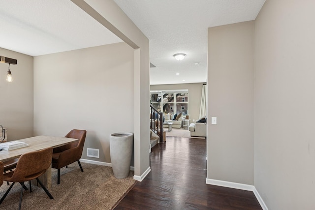 interior space with visible vents, baseboards, stairway, wood finished floors, and a textured ceiling