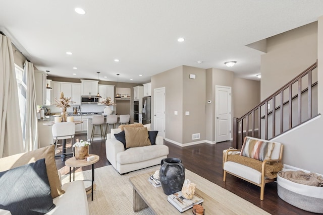 living room with stairs, dark wood-type flooring, recessed lighting, and baseboards