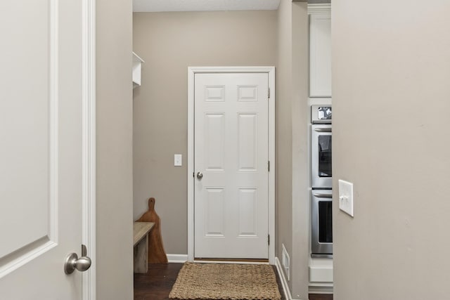 doorway to outside featuring dark wood finished floors and baseboards