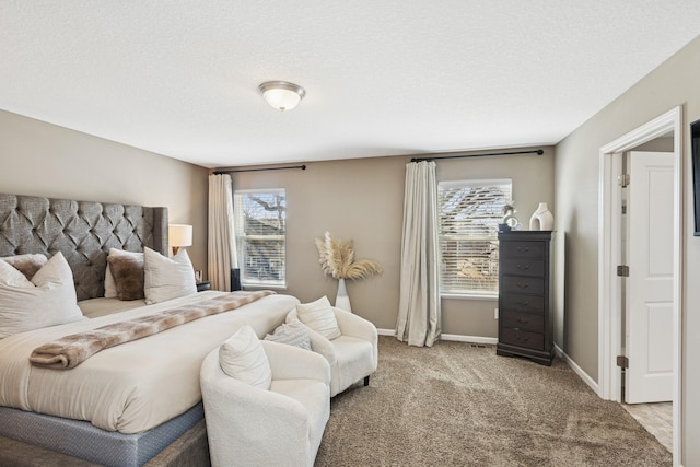 bedroom featuring light colored carpet, a textured ceiling, and baseboards