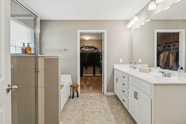 bathroom with tile patterned floors, double vanity, a bath, and a sink