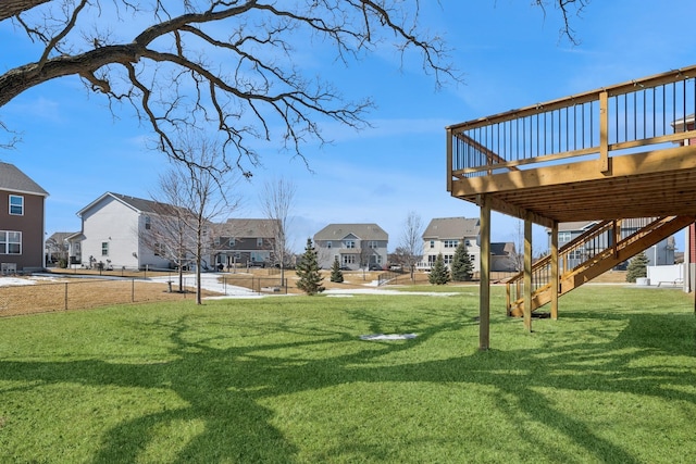 view of yard featuring stairs, a residential view, and a wooden deck